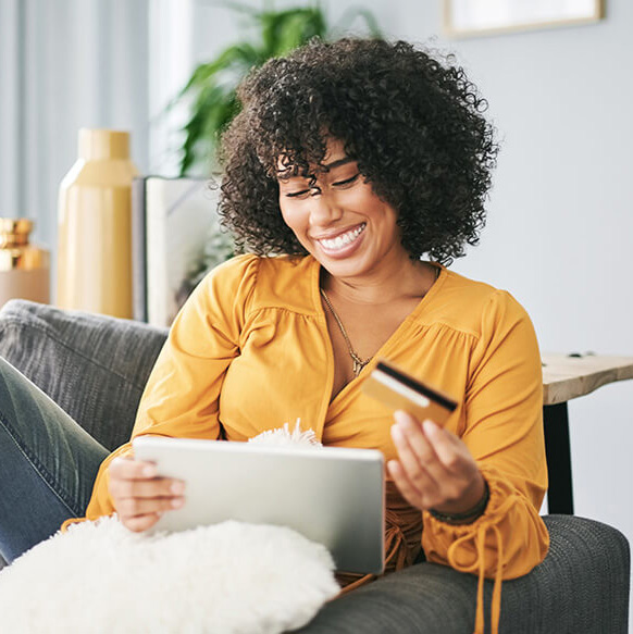 young woman smiling with credit card and tablet