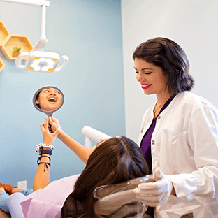 dr with smiling child looking in mirror