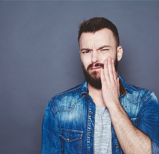 man holding his jaw in pain