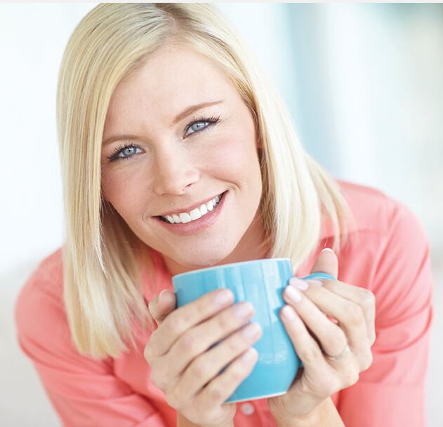 smiling woman holding a cup of coffee