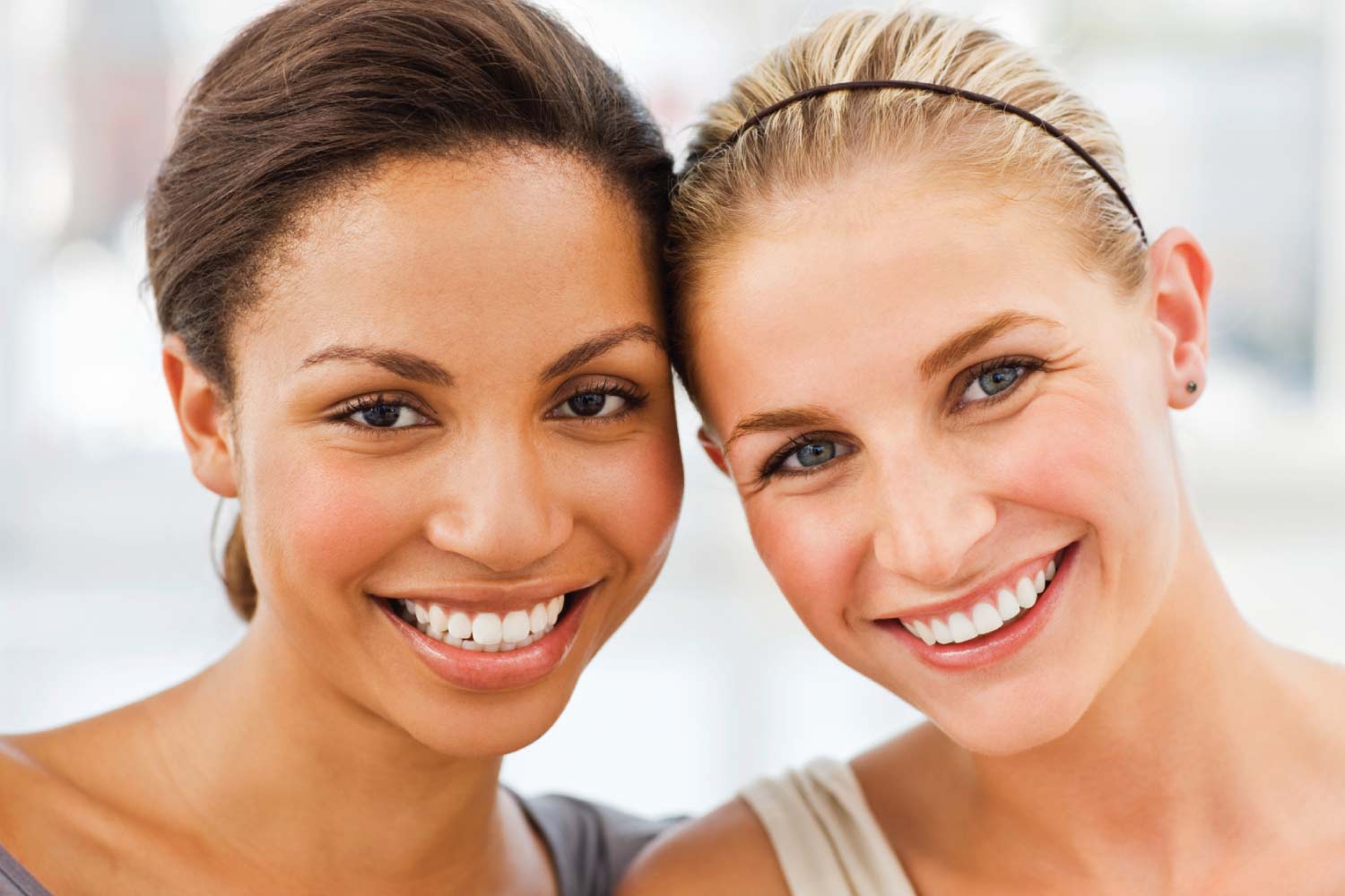 Brunette and blonde woman smile after receiving cosmetic dentistry in Cedar Park, TX, at Dental Salon