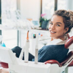 Brunette woman smiles in the dental chair during your biannual dental cleaning & checkup at the dentist in Cedar Park, TX