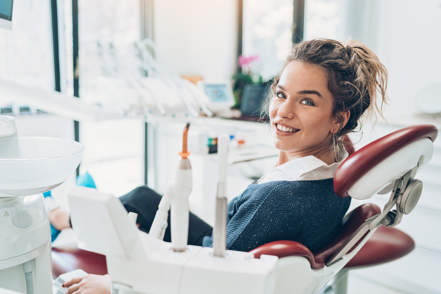 Brunette woman smiles in the dental chair during your biannual dental cleaning & checkup at the dentist in Cedar Park, TX