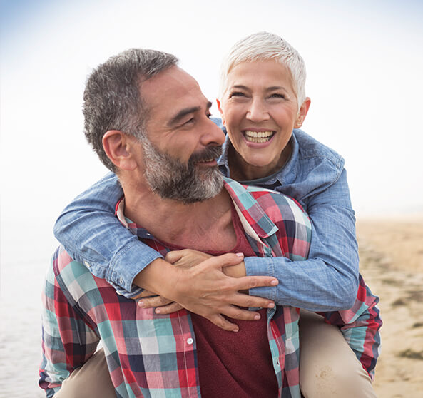 happy senior couple walking on the beach together