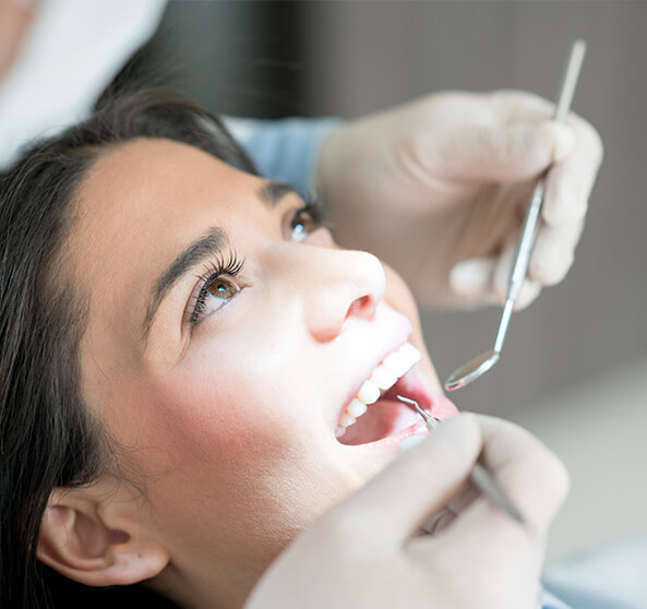 woman having her teeth examined by her dentist