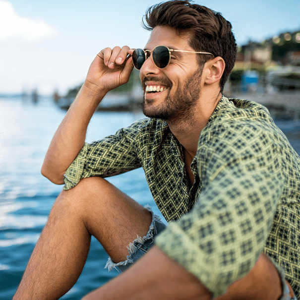 man sitting next to the ocean