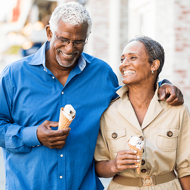 senior couple smiling and eating ice cream