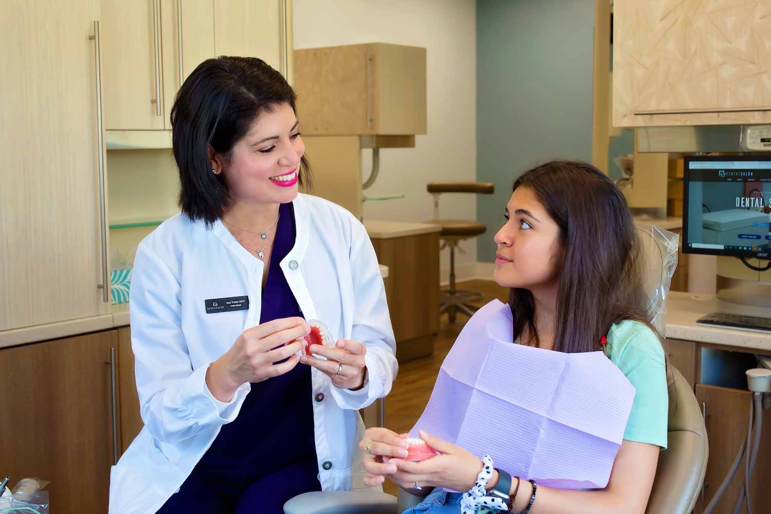 Dr. Torres answers questions for a patient in the dental chair.