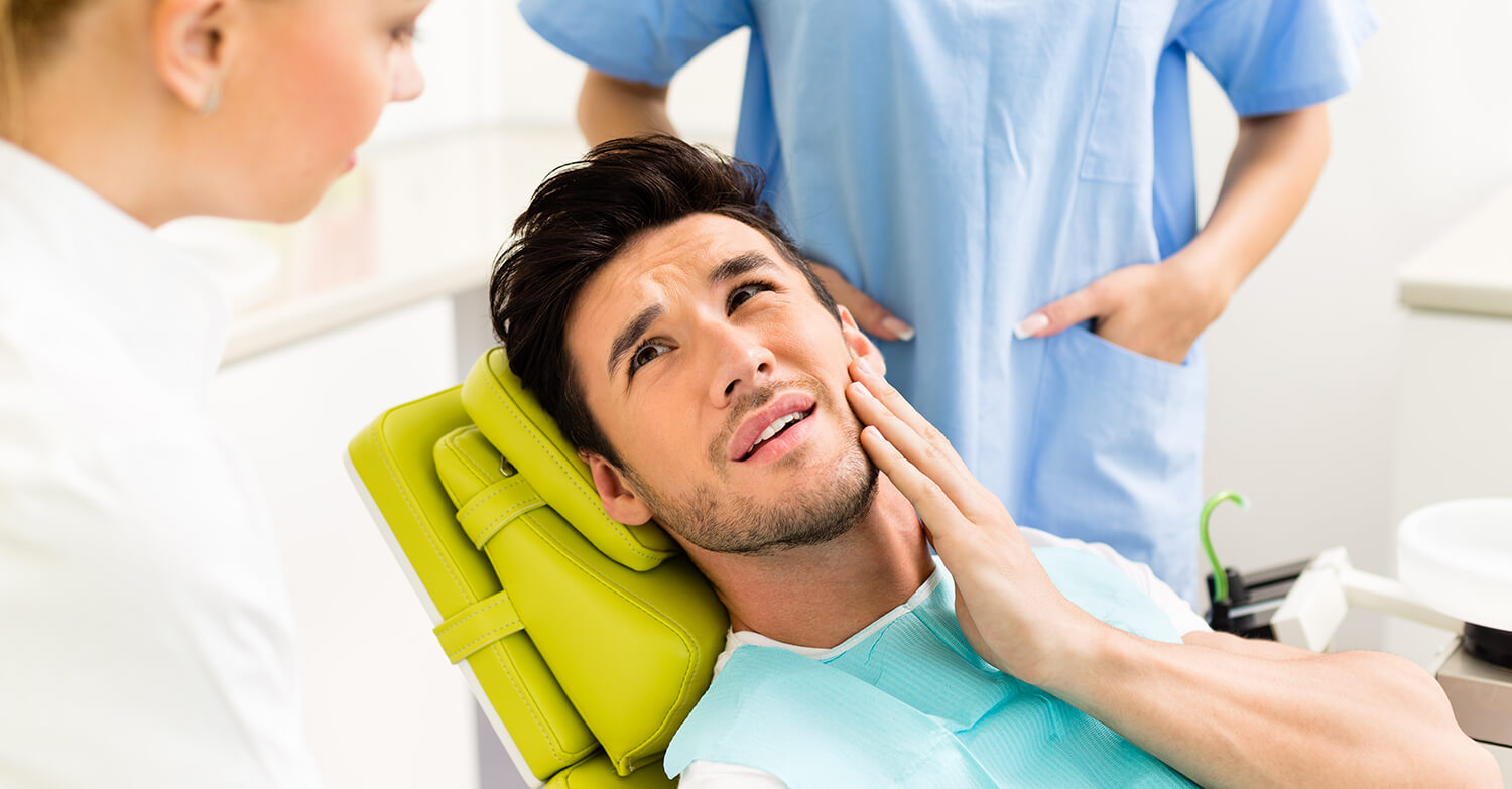 man holding his jaw in pain