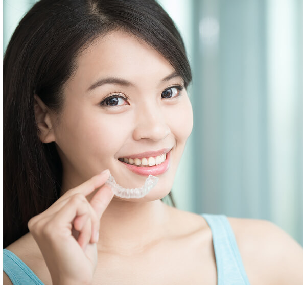 woman holding clear aligner